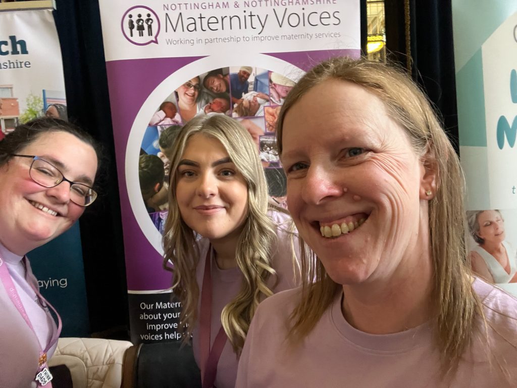 Volunteer speaking warmly with a parent and baby